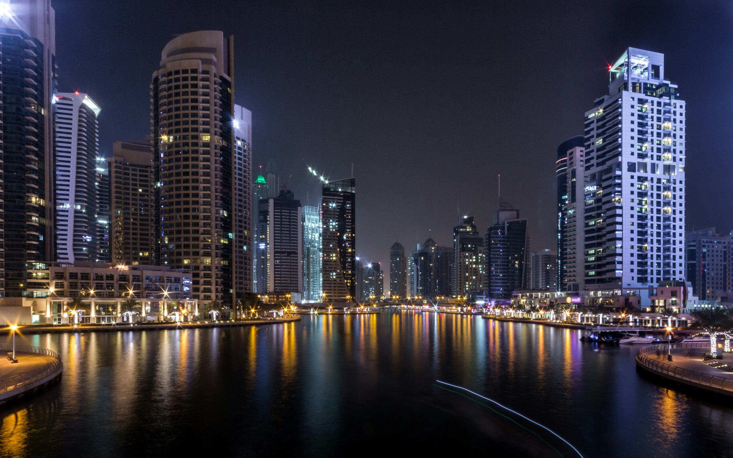 A real estate agent using digital marketing tools to sell a property in Dubai, with social media and website analytics visible on the screen