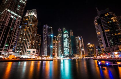 Real estate investor finalizing a property purchase in Dubai, receiving keys from an agent with the city skyline in the background.